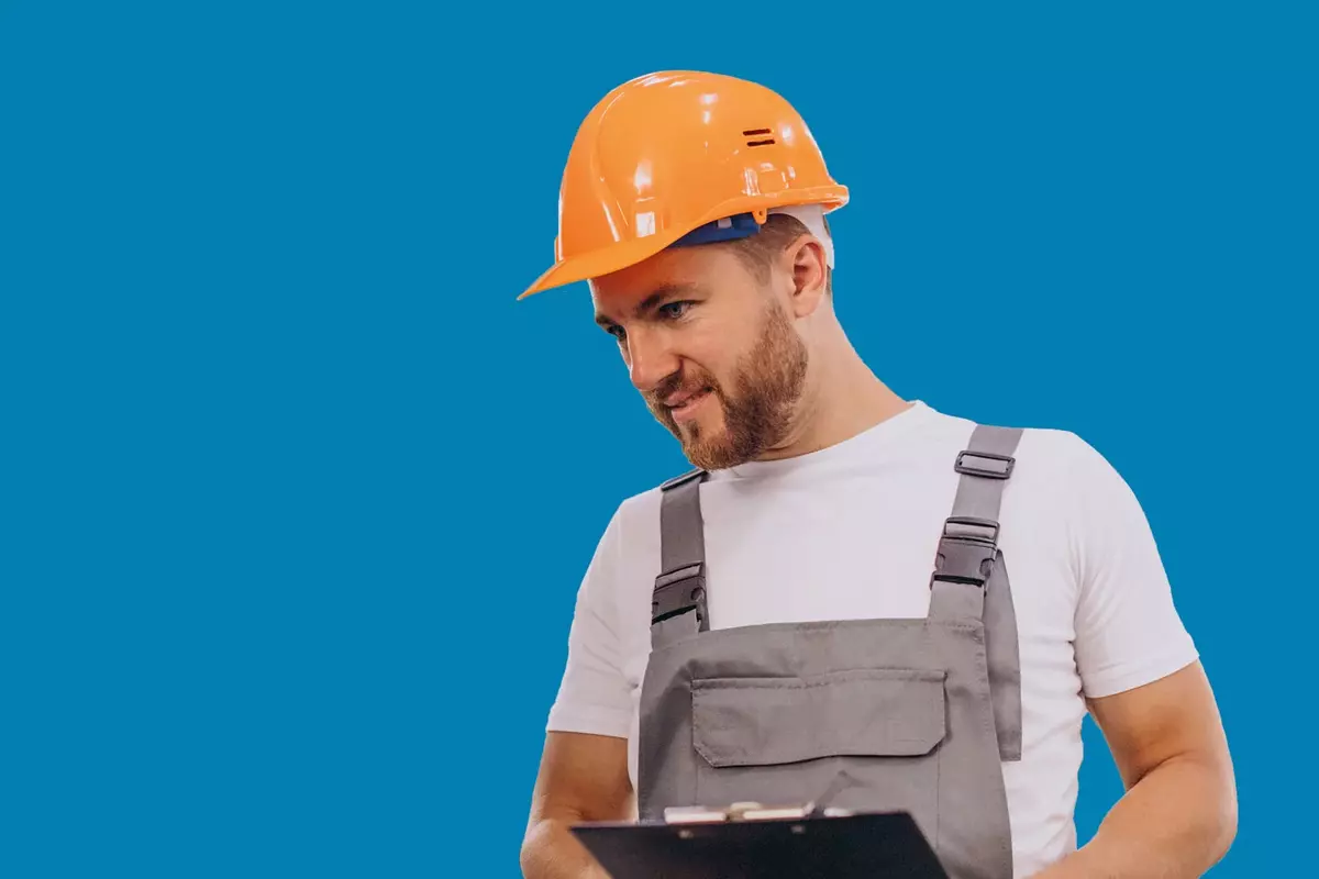 Mann in Produktion mit Helm vor blauem Hintergrund